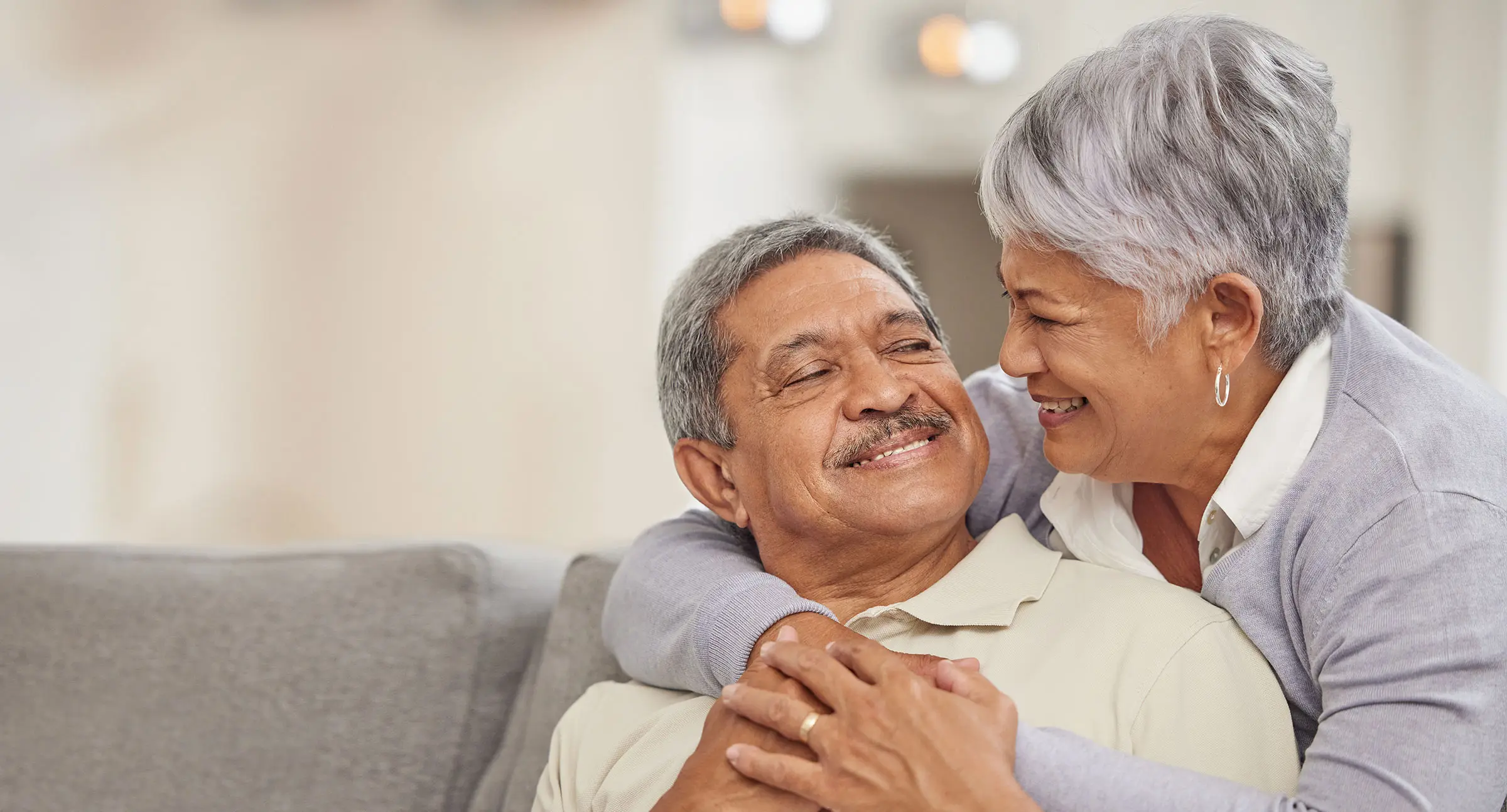 Senior couple hugging on couch