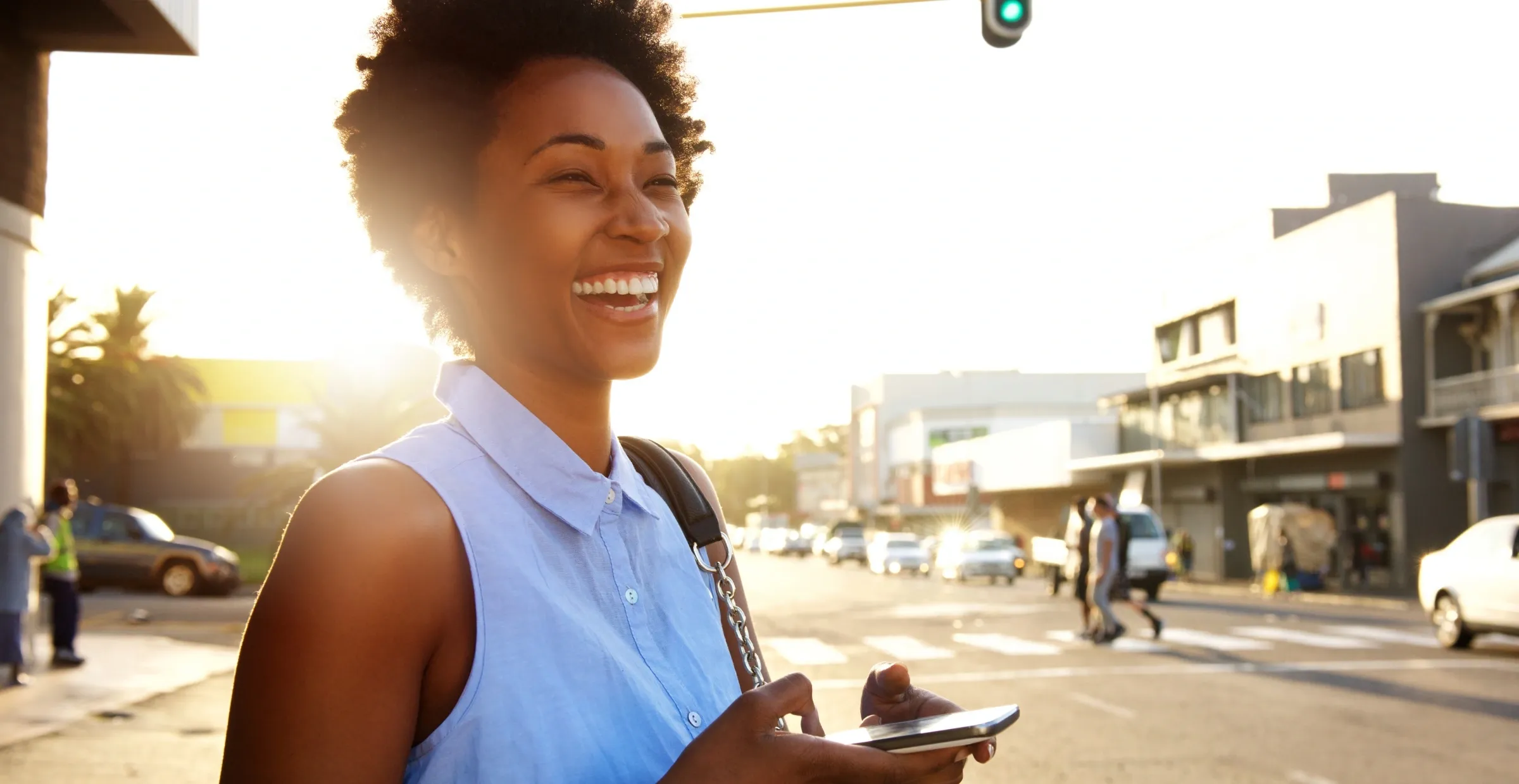 joyful woman looking up from phone in town